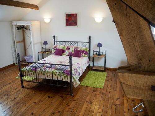 una camera da letto con un letto e un pavimento in legno di Villas de Leypinas Gites a Saint-Pardoux-Corbier