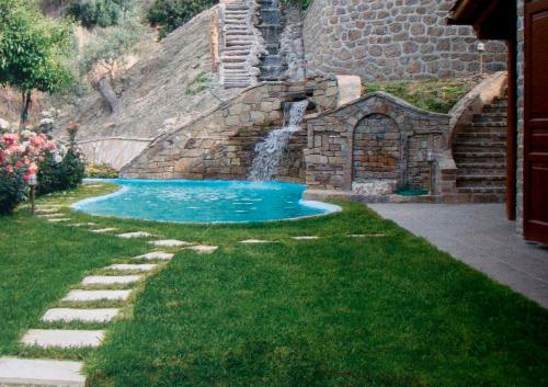 una piscina en un jardín con cascada en Writers' Retreat in Xilokastro, en Xylokastro