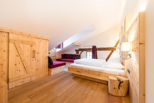 een slaapkamer met een bed en een houten muur bij Gasthof Zur Sonne in Laion