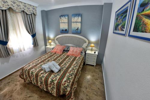 a small bedroom with a bed and two night stands at Chalet El Naranjo in Seville