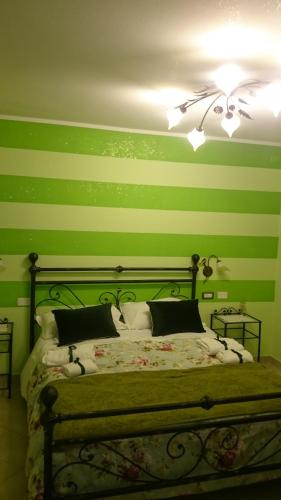 a bedroom with green striped walls and a bed at Affittacamere Villa Giulia in Moneglia
