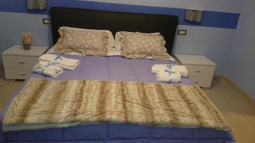 a bedroom with a bed with towels on it at Affittacamere Villa Giulia in Moneglia