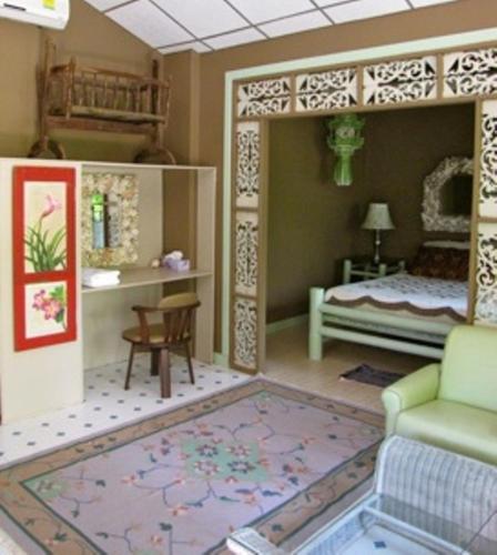 a room with a bedroom with a bed and a rug at Mairood Resort in Ban Mai Rut