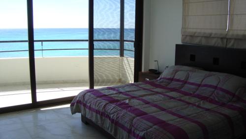 1 dormitorio con cama y vistas al océano en Penthouse with Roof Terrace - Costa Maya en Mahahual