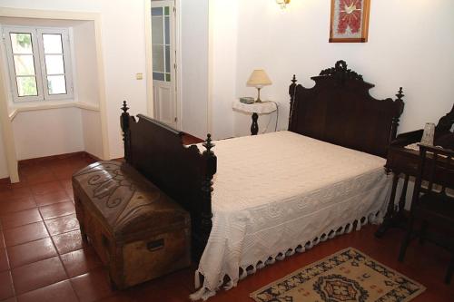 a bedroom with a bed and a table and a window at Ponta Delgada - Casa Rural in Ponta Delgada