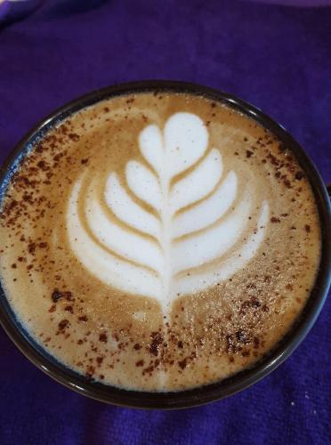 a cup of coffee with a heart drawn on it at G.S Cafe in Magong
