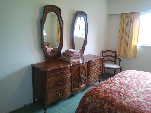 a bedroom with a dresser with a mirror on it at Rosedale Manor in Duncan