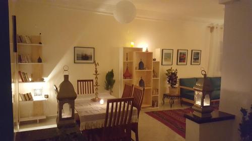 a living room with a table and chairs in it at Dar lhadja in El Jadida