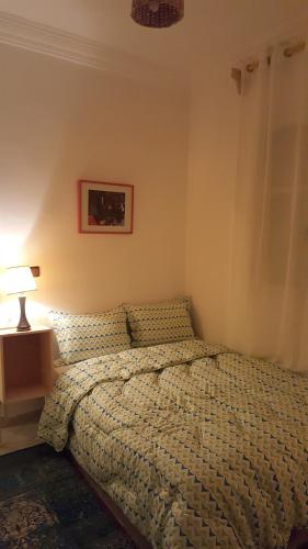 a bedroom with a bed and a lamp on a table at Dar lhadja in El Jadida