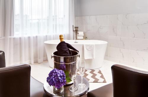 a bottle of champagne in a bucket in a bathroom at Executive Plaza Hotel & Conference Centre, Metro Vancouver in Coquitlam