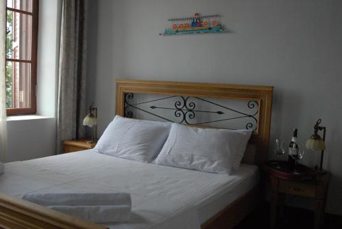 a bed with white sheets and pillows in a bedroom at Aliye Hanim Hotel in Ayvalık