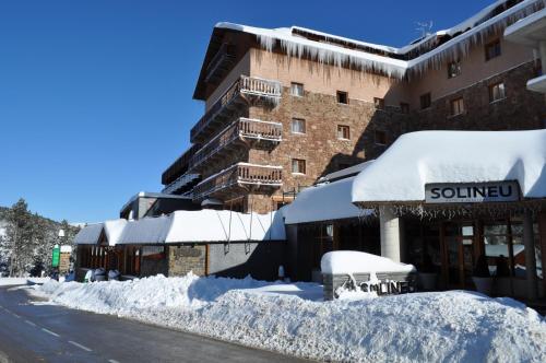 a snow covered street in front of a building at Hotel Solineu in La Molina