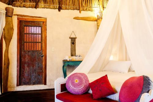 a bedroom with a bed with a canopy at XscapeTulum in Tulum