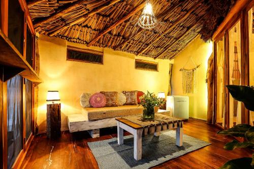 a living room with a couch and a table at XscapeTulum in Tulum