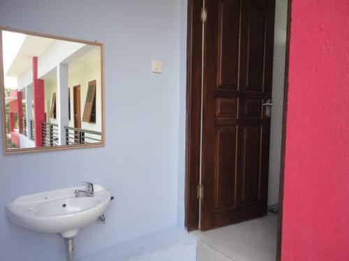 een badkamer met een wastafel en een spiegel bij Jazz Senggigi Hotel in Senggigi 