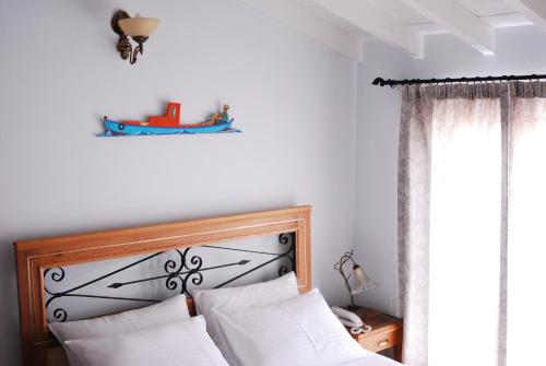 a bedroom with a bed with white pillows and a window at Aliye Hanim Hotel in Ayvalık