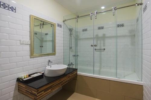 a bathroom with a sink and a glass shower at Aava Malacca Hotel in Melaka