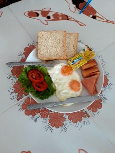 een bord met eieren en brood met worst en groenten bij Number 1 Guesthouse in Ao Nang Beach