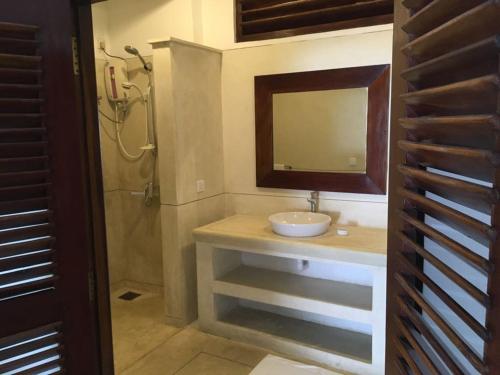 a bathroom with a sink and a mirror and a shower at Sun N Sea Hotel in Unawatuna