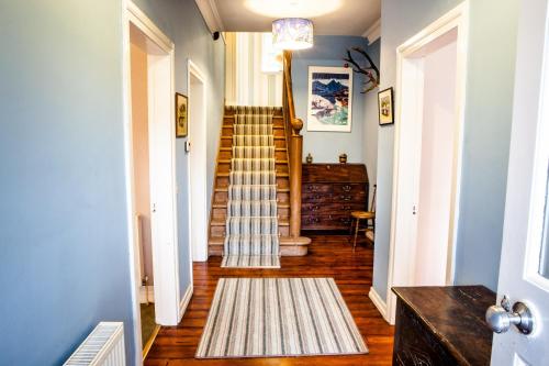 a hallway with a staircase with a rug on the floor at Shelburne Lodge in Cairnbaan
