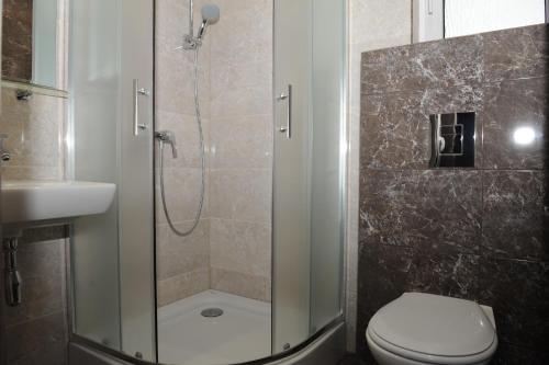 a bathroom with a shower with a toilet and a sink at Penzion Panorama in Liptovský Mikuláš