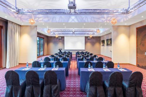 a conference room with tables and chairs and a screen at Ramada Resort by Wyndham Port Vila in Port Vila