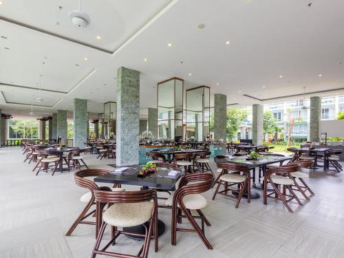 ジンバランにあるザ シンテサ レジデンス ジンバランの建物内のテーブルと椅子のあるレストラン
