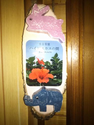 a fish in a pot with a flower in it at Guest House Icyaribacyode in Naha