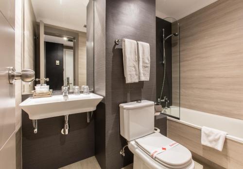 a bathroom with a toilet and a sink at Hotel Alda San Carlos in Santiago de Compostela