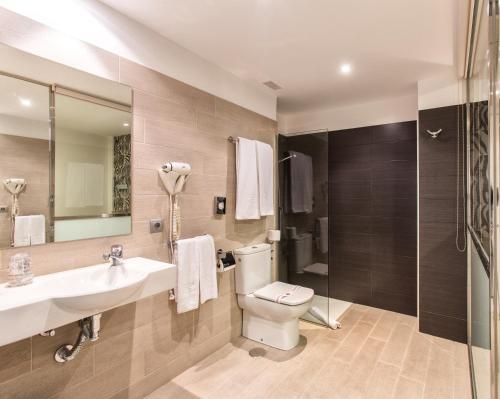 a bathroom with a toilet and a sink and a shower at Hotel Alda San Carlos in Santiago de Compostela