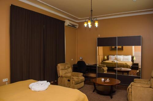 um quarto de hotel com duas camas e uma mesa e cadeiras em Sheva Hotel em Paramaribo