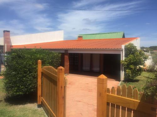 a house with a wooden fence in front of it at Cabañas Marcelo in Barra del Chuy