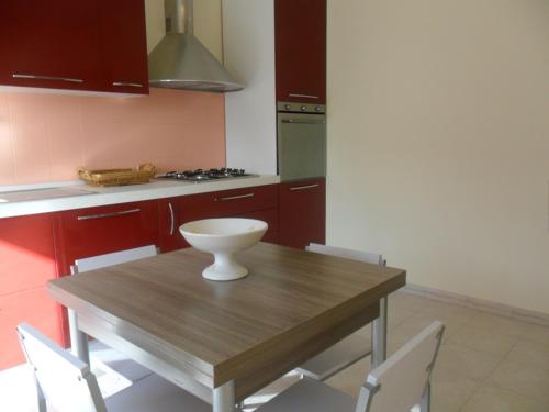 una cocina con una mesa de madera con un tazón. en Appartamento Sacro Cuore, en Módica