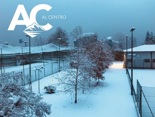 a fence covered in snow next to a building at Al Centro in Verbania