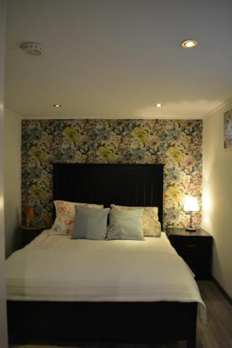 a bedroom with a large bed with a floral wall at Suite 17 in Eindhoven