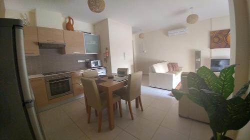a kitchen and dining room with a table and chairs at Pyla Gardens A101 in Pyla