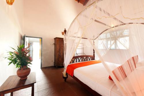 1 dormitorio con 1 cama con mosquitera en Isle of Thalpe en Unawatuna