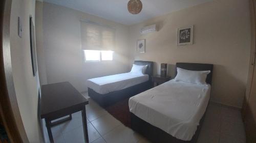 a hotel room with two beds and a table at Pyla Gardens A101 in Pyla