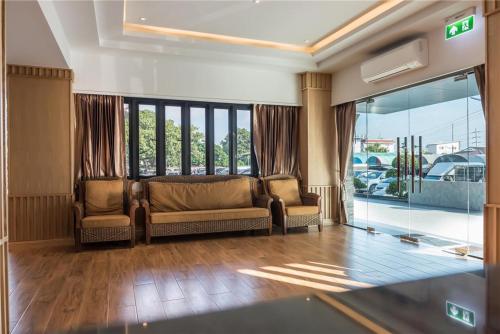 a living room with two chairs and a couch at Golden Foyer Suvarnabhumi Airport Hotel in Lat Krabang