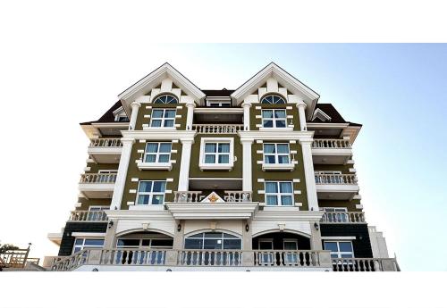 a tall yellow and white building with a balcony at Pension Badawa in Gangneung