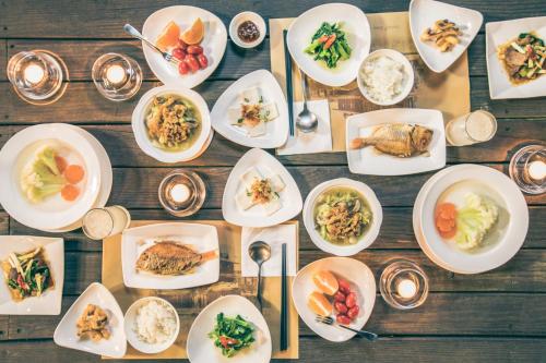 a table with plates of food and bowls of food at Sunday Home in Dayin
