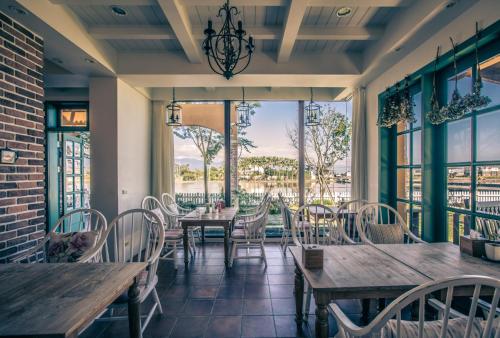 a restaurant with wooden tables and chairs and large windows at Sunday Home in Dayin