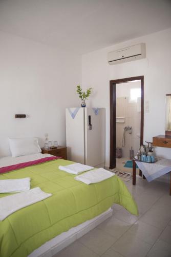 a bedroom with a green bed and a refrigerator at Psiloritis in Kalamaki Heraklion