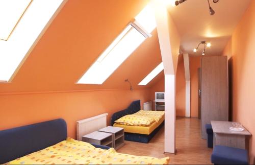 a attic room with two beds and skylights at HOTEL Villa Romaine in Šahy