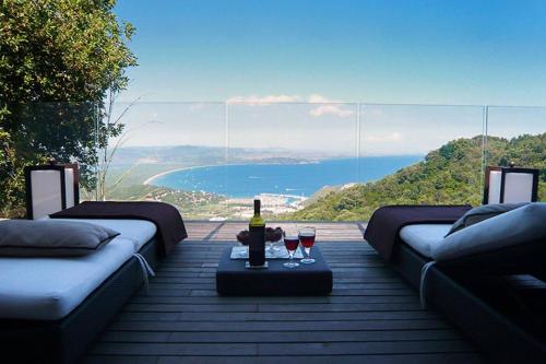 a table with two glasses of wine on a deck at Villaflair - Design Villa Porto Ercole in Monte Argentario