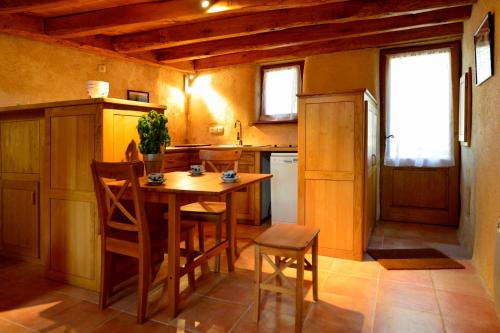 une petite cuisine avec une table et des chaises en bois dans l'établissement La Coutinelle, à Le Salson
