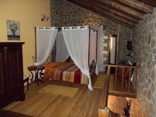 a bedroom with a bed with curtains in a room at Theasis suites-Ορεινή Φιλοξενία in Kato Trikala Korinthias