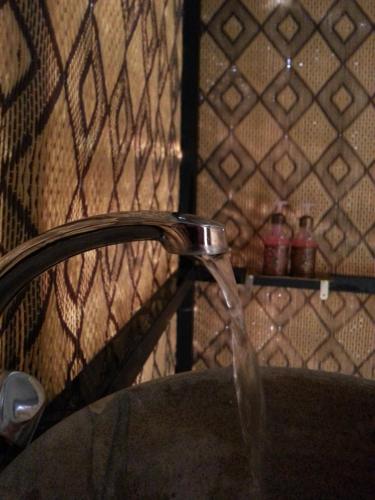 a bathroom sink with water coming from a faucet at Morocco Deluxe Camp - Assif n'Itrane in Lac Yasmins