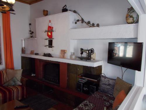 a living room with a fireplace and a tv at Theasis suites-Ορεινή Φιλοξενία in Kato Trikala Korinthias
