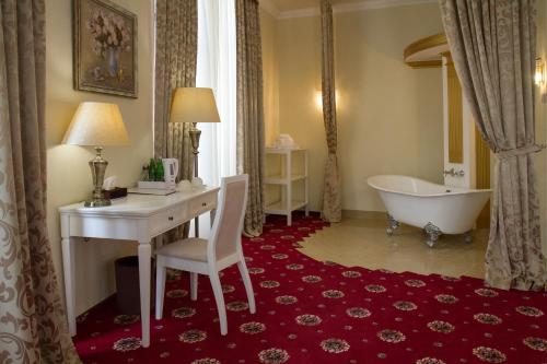 a bathroom with a tub and a desk and a claw foot tub at City Holiday Resort & SPA in Kyiv